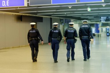 Silahlı dört genç polis, Frankfurt am Main Havalimanı genel olarak koridorunda dolaşır, yolcu giriş terminali, güvenlik kontrolü kavramı ve havaalanındaki kolluk kuvvetleri