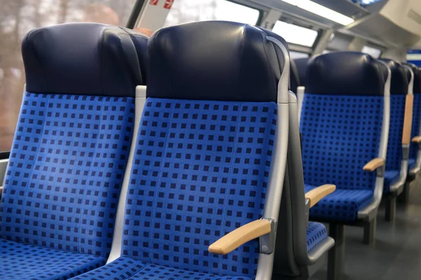 comfortable soft blue seats with headrests in half-empty train car in Germany, concept of long-distance travel, ticket for stowaways, transporting second-class passengers, being late for your train