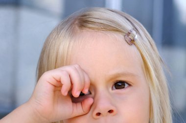 part of the child's face close-up, child of 3-4 years old closed one eye with a palm, looks into the hole, concept of children's whims, parental abuse, psychological abuse, happy childhood