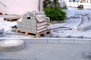 gray paving blocks on ballast, sewer well, construction site of pavement modern granite cobblestone road in city center, roadworks stonework at pedestrian area, concept installation, renovation