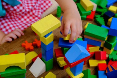 smart little child, girl 3 years old playing with educational toy, wooden geometric figures, blocks, kindergarten games, concept of childhood, earlier child development, creativity, early training