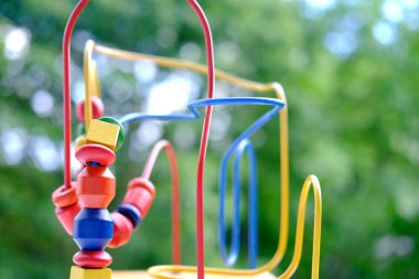 çocuklar için renkli ahşap eğitim labirenti, iyi motor becerileri geliştirme, Bokeh ile güzel yeşil arka plan, yaratıcılığın gelişimi konsepti, evde ve anaokulunda oyun etkinliği