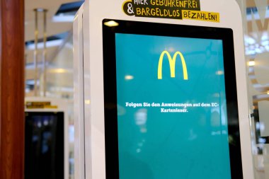 electronic menu with logo of the restaurant McDonald's in lobby of airport, concept fast food, travel, voyage, eat between flights, Frankfurt - August 2022