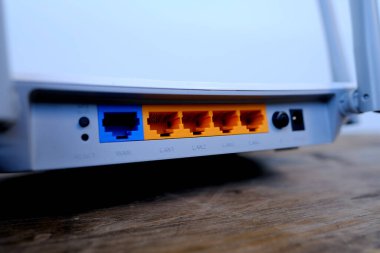 Wi-Fi router output ports close-up, modern wireless Router with four non-removable external antennas for better search and signal transmission on wooden table, concept high speed data processing