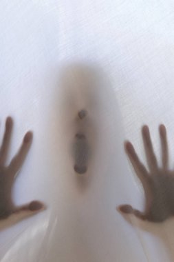 eerie blurry hands of people as if they have been trapped behind glass, dense fabric, wrap, ghost, spirit trying to reach out from afterlife, concept of violence, nightmares, halloween horror