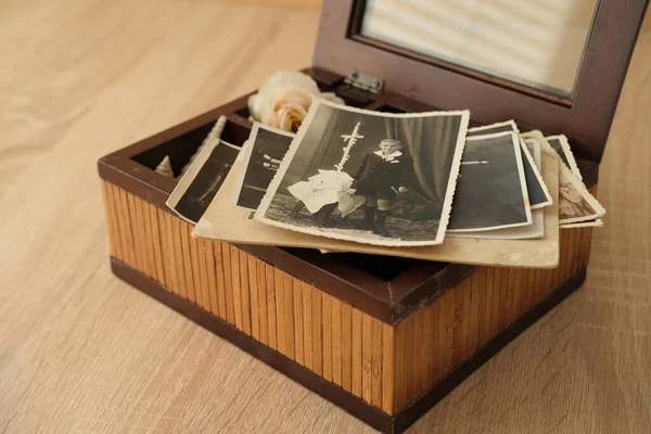 close-up old vintage photos 50s, 60s sepia color in brown wooden box, chest, concept of antique treasure, family tree, genealogy, memory of ancestors, family ties, childhood memories