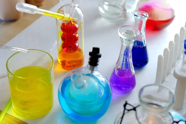 9岁的孩子 小学生 做化学实验 把彩色液体倒入玻璃瓶 混合颜色 学校教育理念 亲自动手学习化学 — 图库照片