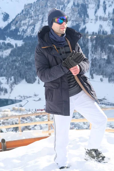 young man wearing sunglasses, mountain hiker admiring mountain winter landscape, Sports Concept, Healthy Lifestyle, Winter Activity, beautiful winter natural landscape, walks in winter white forest