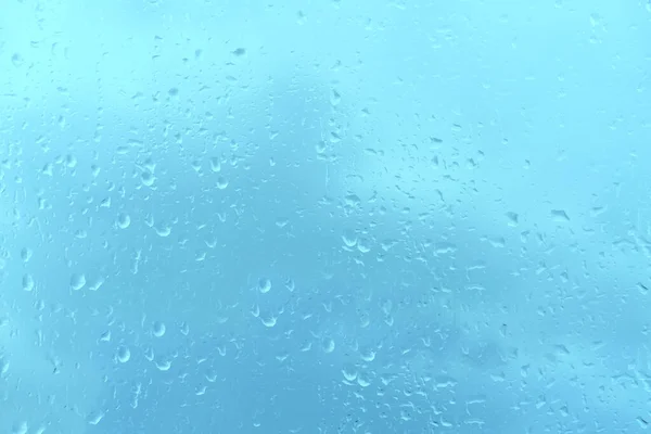 ウィンドウ内の美しい雲の風景 水滴とガラスの背景の青のテクスチャ テキストのための場所 ぼやけたボケと水平方向のバナー 自然保護 厳しい天候 — ストック写真