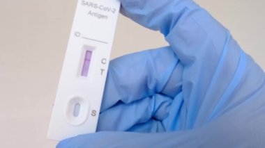 Yakın plan kadın eli PCR test kasedini tutuyor, şerit boyanmış, asistanı tıbbi bilimsel laboratuvarda test yapıyor, genetik örnek örneği karıştırıyor, covid-19 enfeksiyonu kavramı
