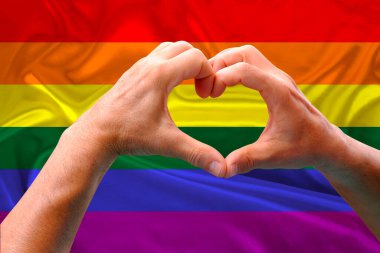 LGBT gökkuşağı bayrağı, Gurur bayrağı, Özgürlük bayrağı - lezbiyen, eşcinsel, biseksüel ve transseksüel topluluğun uluslararası sembolü, kalp şeklinde erkeklerin elleri, insan hakları hareketi kavramı