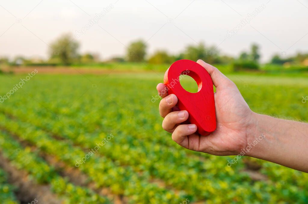 Red location pin on farm field. Buying and selling on land market. Plot Boundary Demarcation service. Legal regulation of property. Agriculture and agribusiness. Land tenure, landownership