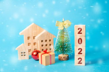Ahşap bloklar 2022, Noel ağacı ve minyatür evler. Yeni yıl ya da Noel kış tatili. Dekorasyon, kutlama. Yeni yılın başlangıcı konsepti. Mavi arkaplan