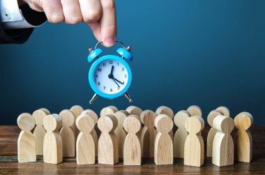 Bir iş adamı kalabalığın üzerinde çalar saat tutuyor. Zaman yönetimi. Saatlik ücretler, sıkı çalışma limitleri ve dinlenmek için tahsis edilen zaman. Acilen, hızlanarak, son teslim tarihi. Deneme, deneme süresi
