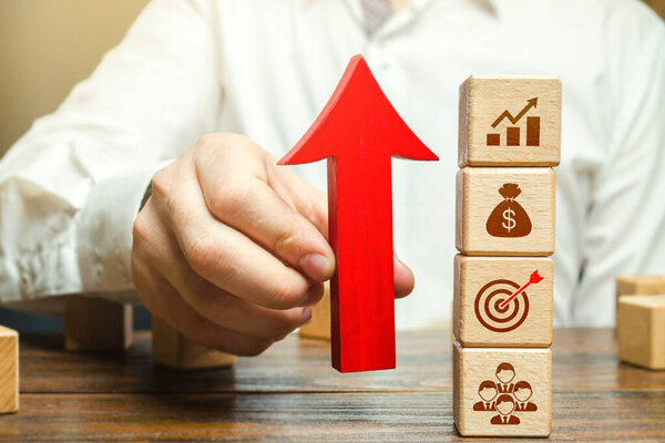 Businessman holds an up arrow near business attributes. Expansion of business company. Using new approaches and tools. Development of leadership organizational skills. Entrepreneurship management.