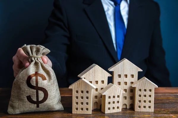 Businessman Puts Dollar Money Bag Houses Investments Real Estate Assets — ストック写真