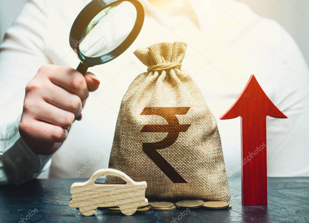 A woman inspects a indian rupee money bag and a car. Growing sales. Electric vehicle support subsidies. Expensive car maintenance. High price of insurance. Increase in prices. Rise fuel excise taxes