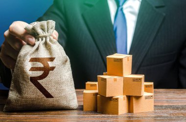 İş adamı Hint Rupisi para çantasını ve kutuları elinde tutuyor. İthalat ve ihracat. İş geliri. Vergi ve aidat ödemeleri. Reklam bütçesi. Mal, ticaret ve ticaret alım-satımı.