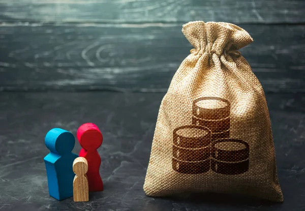 Family figurines near the money bag. Social assistance and support. Income level, budget. High debt. Segmentation. Marketing and targeting. Demographic grant. Social research, consumer preferences.