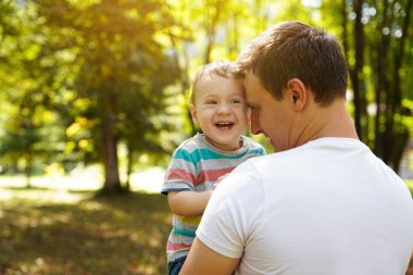 Dad plays with his little son in the garden outdoors. Family pastime. Happy smiling people. Boy of one and a half years. Toddler. Selective focus
