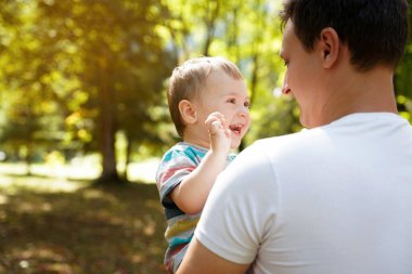 Dad plays with his little son in the garden outdoors. Family time. Happy smiling people. Boy of one and a half years. Toddler. Selective focus