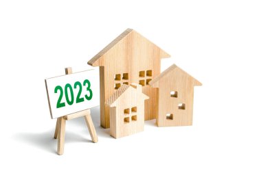 Houses and 2023 sign. Mortgage loan rates. Review real estate market in new year. Forecast new trends and changes in housing tendencies. Economic analysis and investment plans. News and events