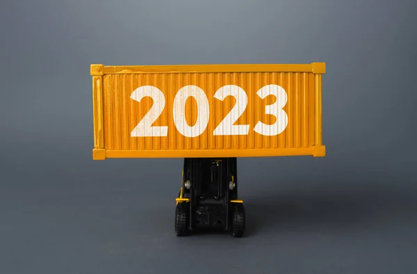 Forklift with a shipping container with 2023. Analytics forecasting of freight traffic next year. Develop infrastructure projects. Express delivery, goods transportation. Logistics. Import export.