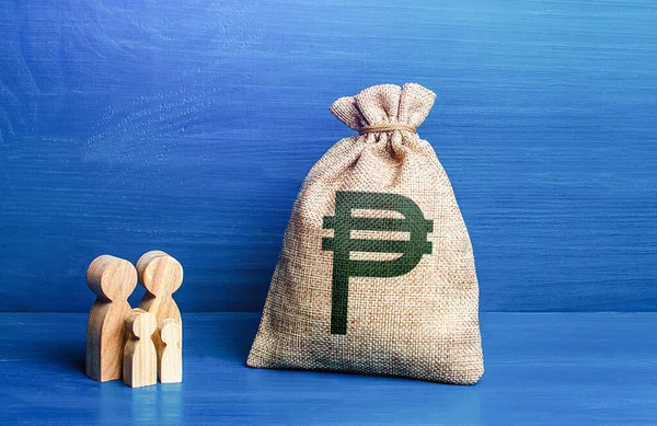 Family figurines and philippine peso money bag. Family budget. Income, expenses. Refugees crisis. Investment in human capital. Favorable conditions for population growth. Demography.