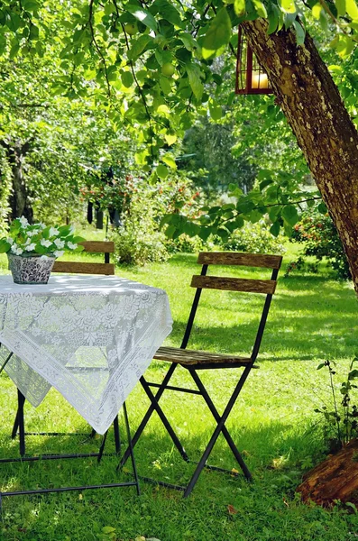 Entorno idílico de una pequeña mesa de centro y una silla de madera — Foto de Stock