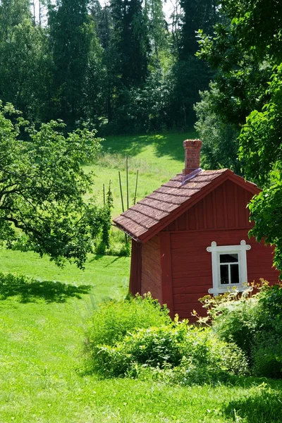 Красный идиллический коттедж в летнем пейзаже — стоковое фото