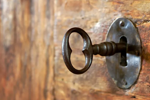 Primo piano di un vecchio buco della serratura con chiave Immagine Stock