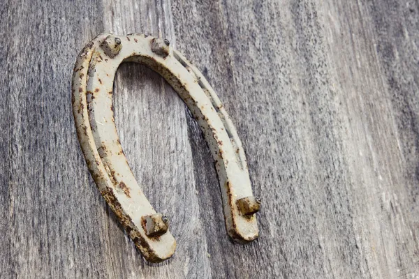 Vieux fer à cheval sur un fond en bois — Photo