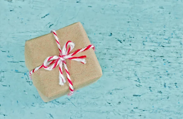 Coffret cadeau enveloppé dans du papier brun avec fil rayé rouge — Photo