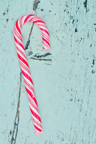 Single candy cane on a wooden background — Stock Photo, Image