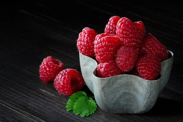 Tasse Himbeeren auf dunklem Hintergrund — Stockfoto