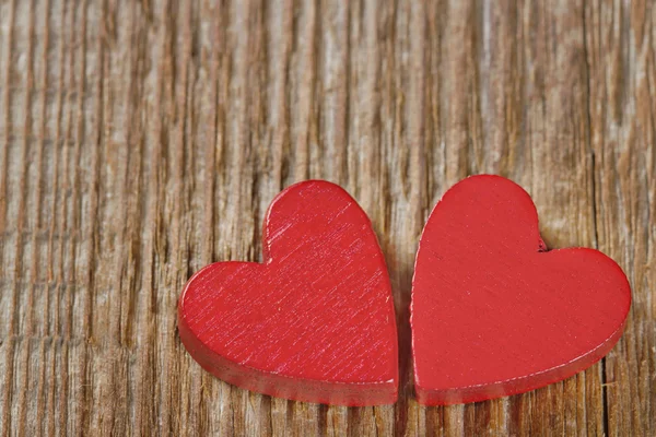 Dos corazones rojos sobre fondo de madera — Foto de Stock