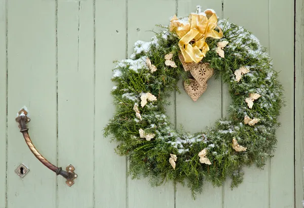 Green Christmas wreath on a wooden door — Stock Photo, Image