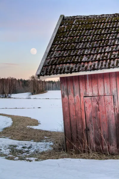 Ancienne grange rouge dans un paysage enneigé — Photo