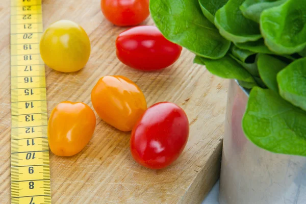 Salad, tomatos and measurement tape — Stock Image Salad, tomatos and measurement tape Stock Photo