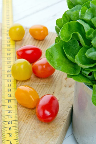 Tomatos, salad and measurement tape — Stock Image Tomatos, salad and measurement tape Royalty Free Stock Photos