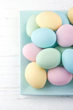 Beyaz ahşap arka plan üzerinde renkli Paskalya yumurtaları