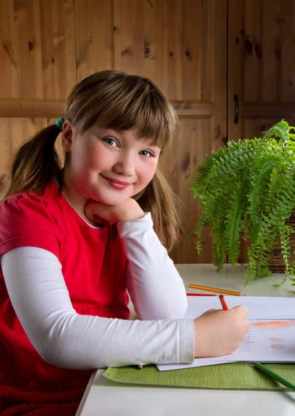 Nettes kleines Mädchen zeichnet an ihrem Schreibtisch — Stockfoto