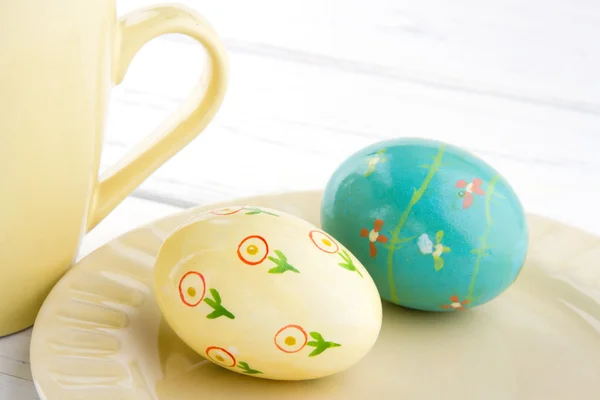 Painted easter eggs on light yellow plate — Stock Photo, Image
