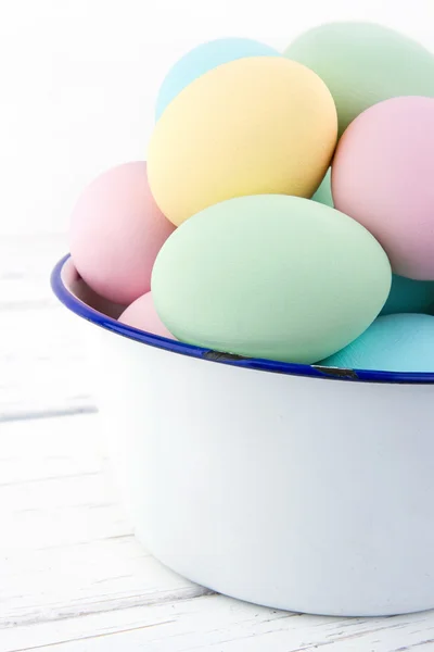 White old bowl full of pastel colored easter eggs — Stock Photo, Image