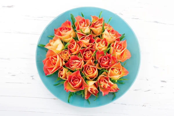 Roses on blue plate — Stock Photo, Image