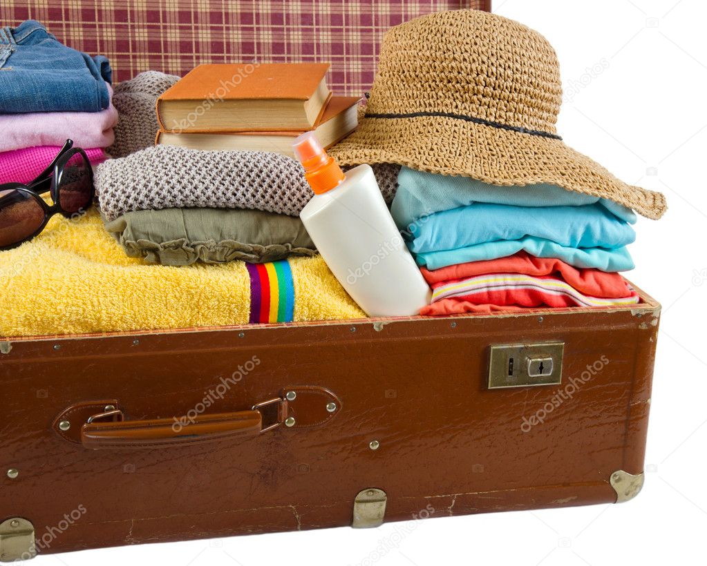 Old vintage suitcase packed with clothes and vacation accessorie