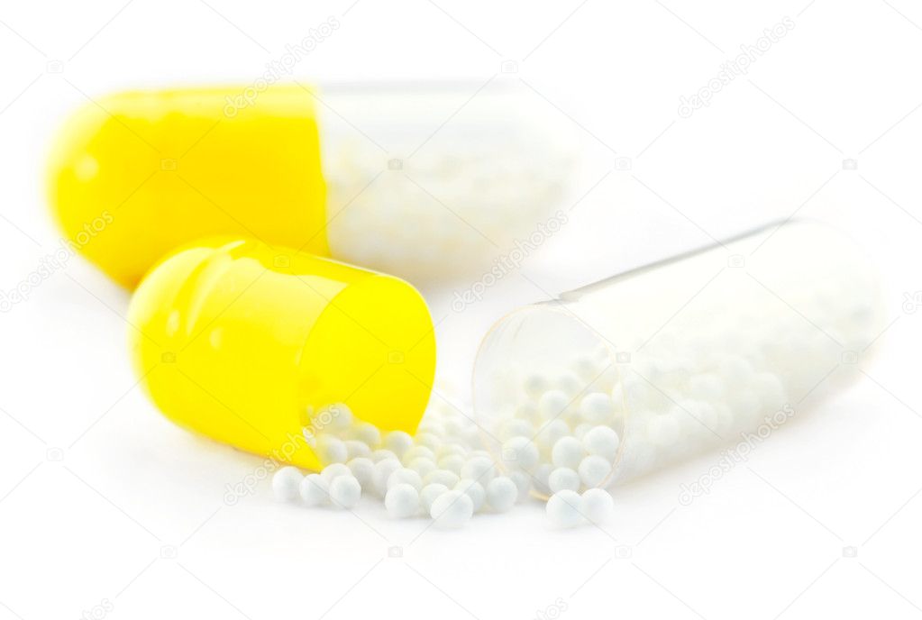 Open medicine capsule on white background