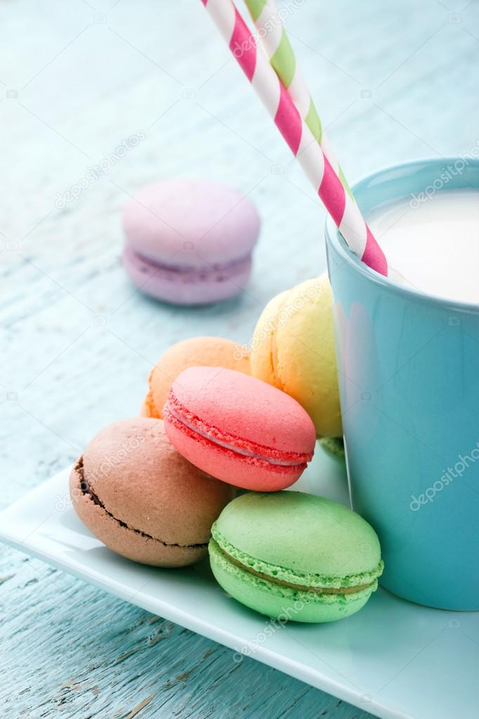 Pastel color macaroons and a cup of milk