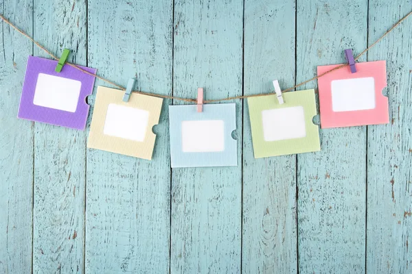 Five empty photo frames hanging with clothespins — Stock Photo, Image