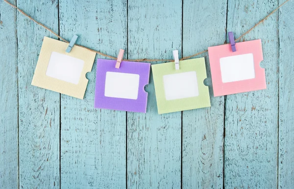 Four empty photo frames hanging with clothespins — Stock Photo, Image